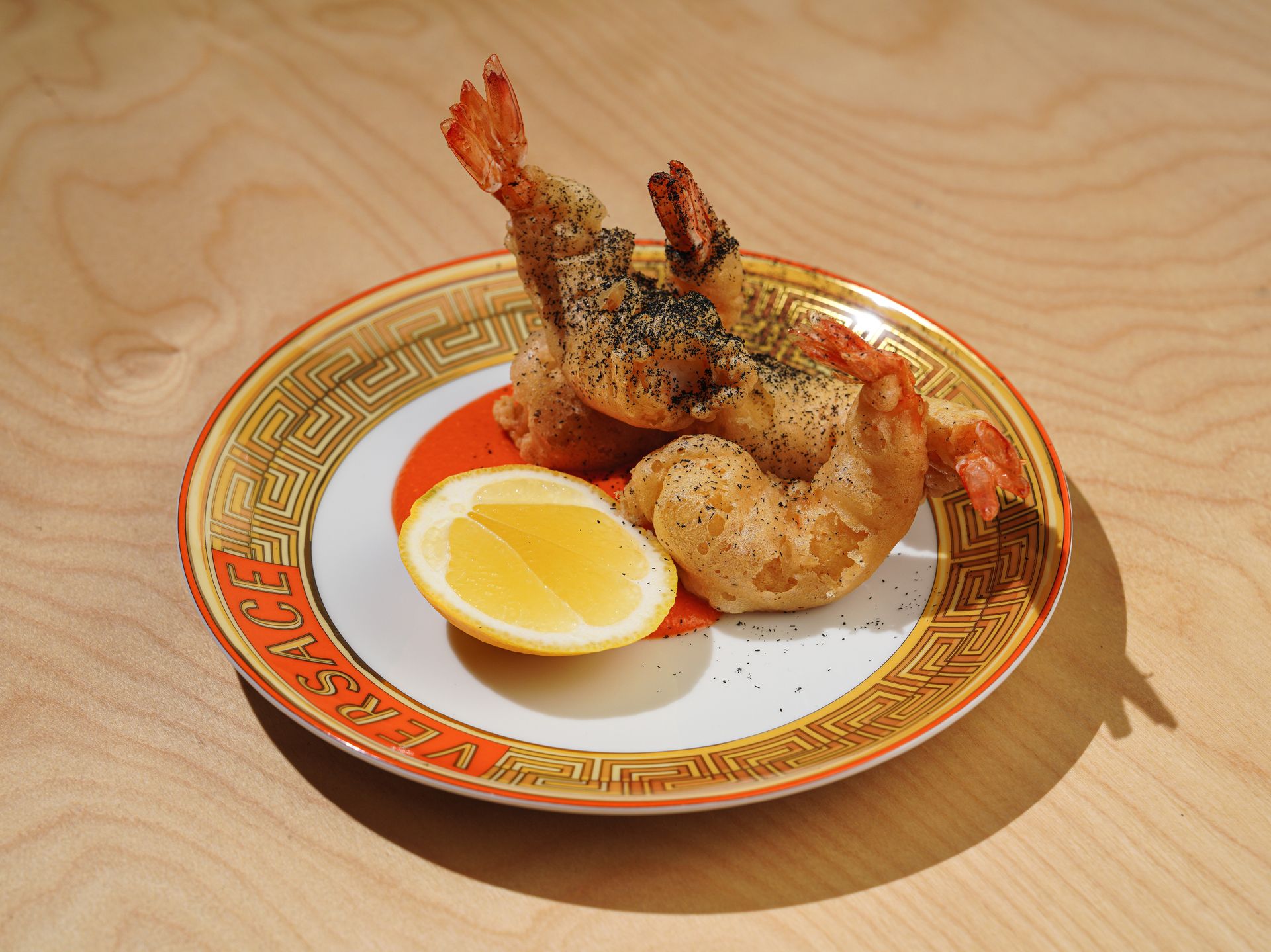 Delicious tempura shrimp with lemon on a designer Versace plate.