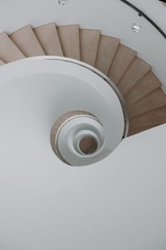 A captivating top view of a modern spiral staircase with natural wood tones, perfect for architectural inspiration.
