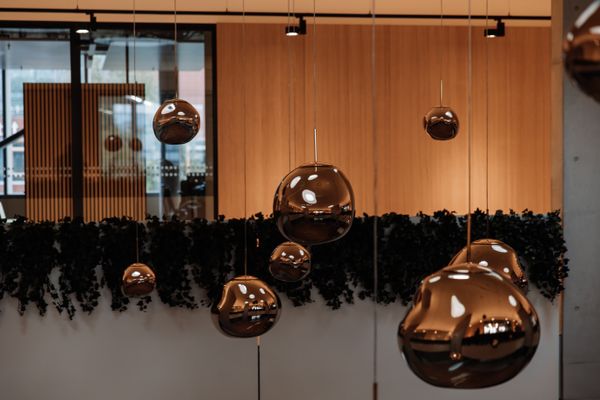 Warm office interior with copper pendant lamps and timber panelling — Eddson Lens on Pexels