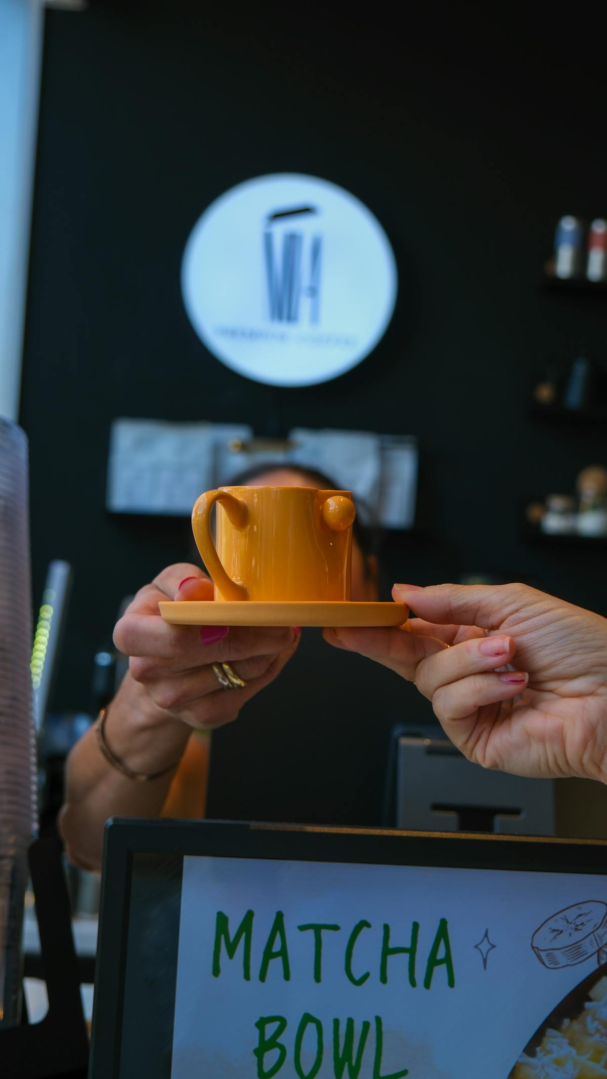 Barista porge una tazza di caffè a un cliente nel caffè accogliente.