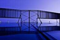 这幅抽象视图展现了现代建筑元素，配有引人注目的倒影和蓝色色调