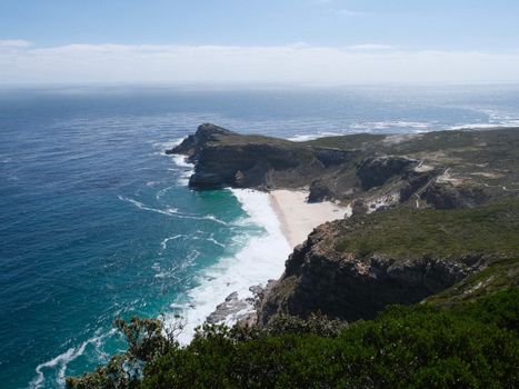 Beautiful coastal landscape of Cape Peninsula, South Africa, featuring rugged cliffs and turquoise waters.