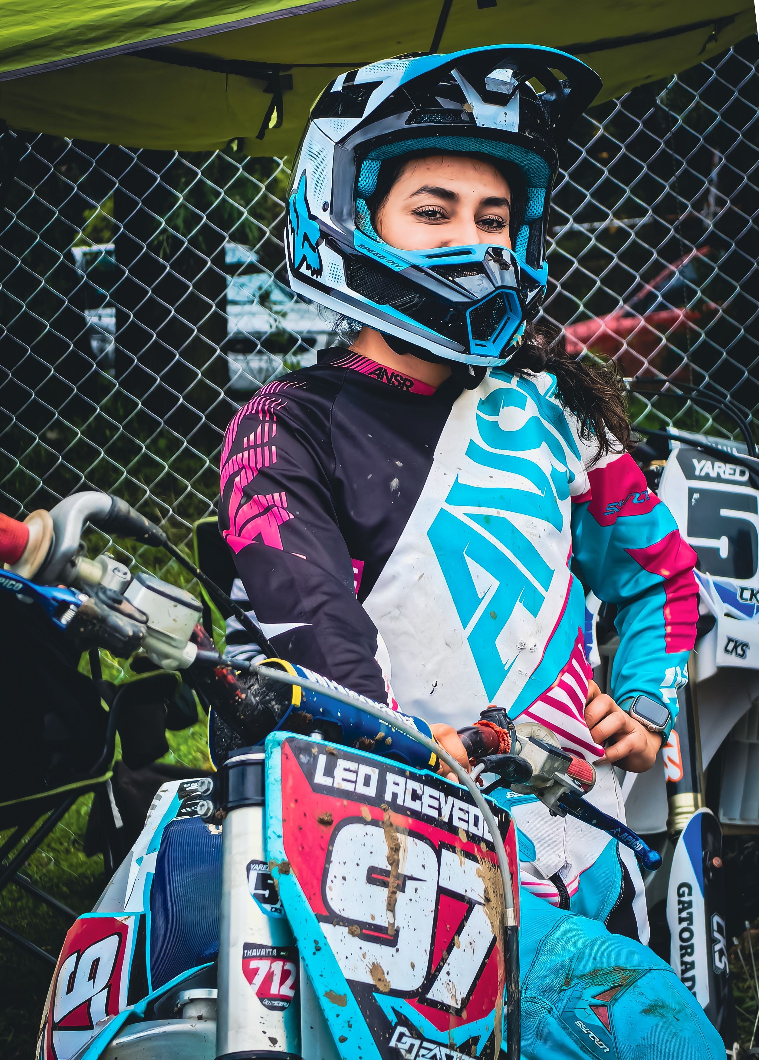A focused young motocross racer ready to ride in vibrant protective gear.