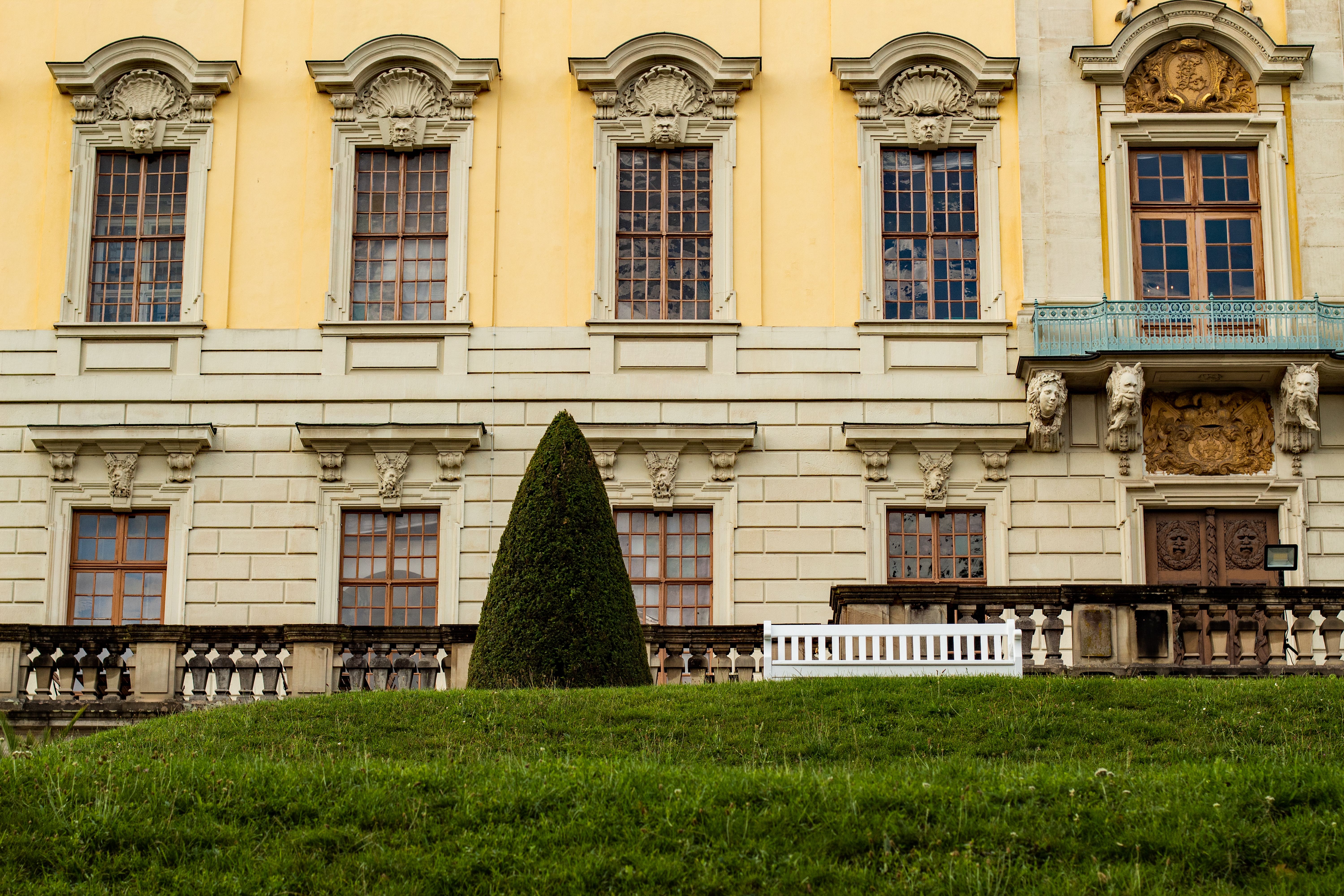 The pink rococo facade of Queluz National Palace above its clipped formal gardens