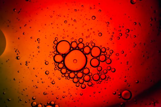 Close-up of abstract oil bubbles on a striking red liquid background.