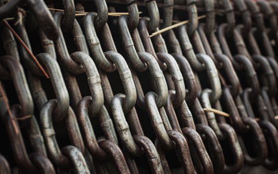 Closeup of aged metal chains creating an industrial and rustic feel, ideal for backgrounds.