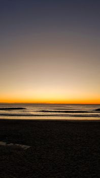 Serene sunrise view over Mar del Plata beach, Argentina, with calm waves and clear skies.