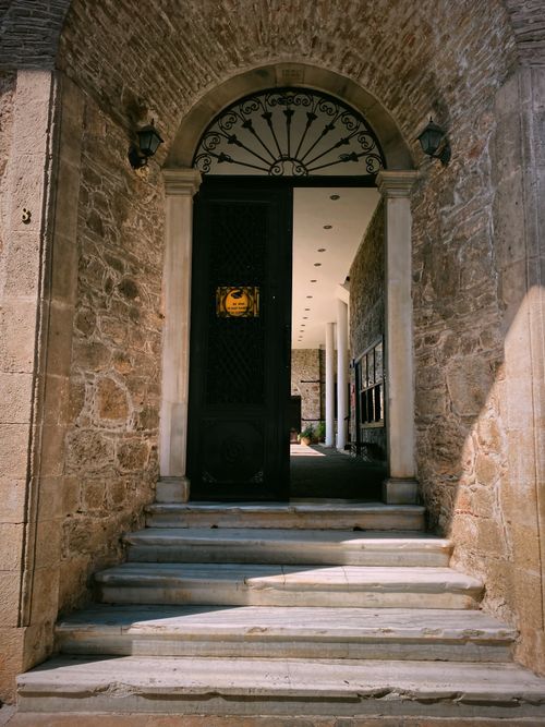Free Elegant stone archway with intricate details leading into a historic building entrance. Stock Photo