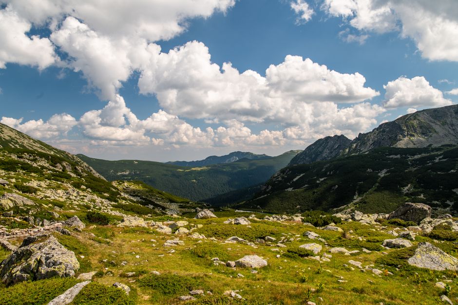 Stunning view of green alpine meadows under dramatic clouds.