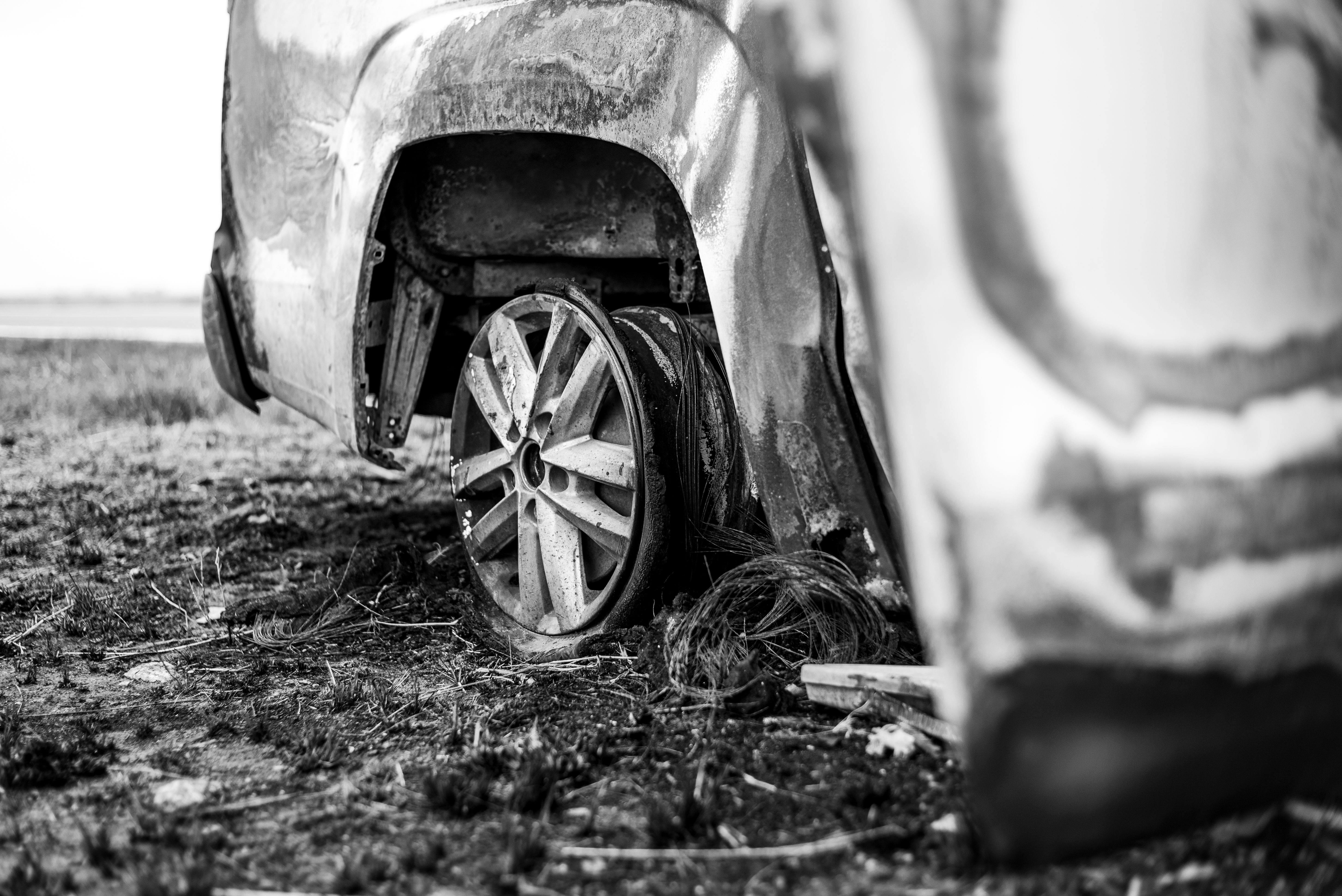 Driver photographing vehicle damage from accident for insurance claim