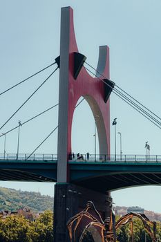 Stunning view of Bilbao's famous red suspension bridge under a clear blue sky.