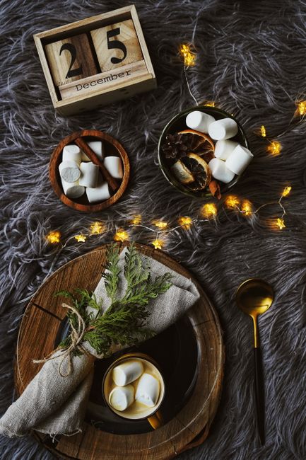 A warm and inviting Christmas flatlay with hot cocoa, marshmallows, and festive decor.