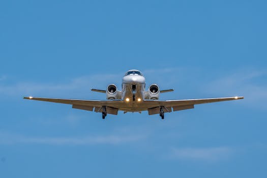 Front view of a private jet approaching for landing against a clear sky at Manises, Spain.