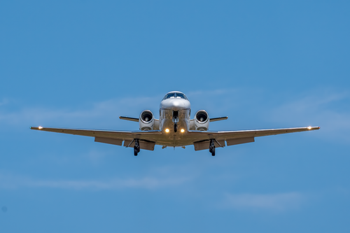 Free Front view of a private jet approaching for landing against a clear sky at Manises, Spain. Stock Photo
