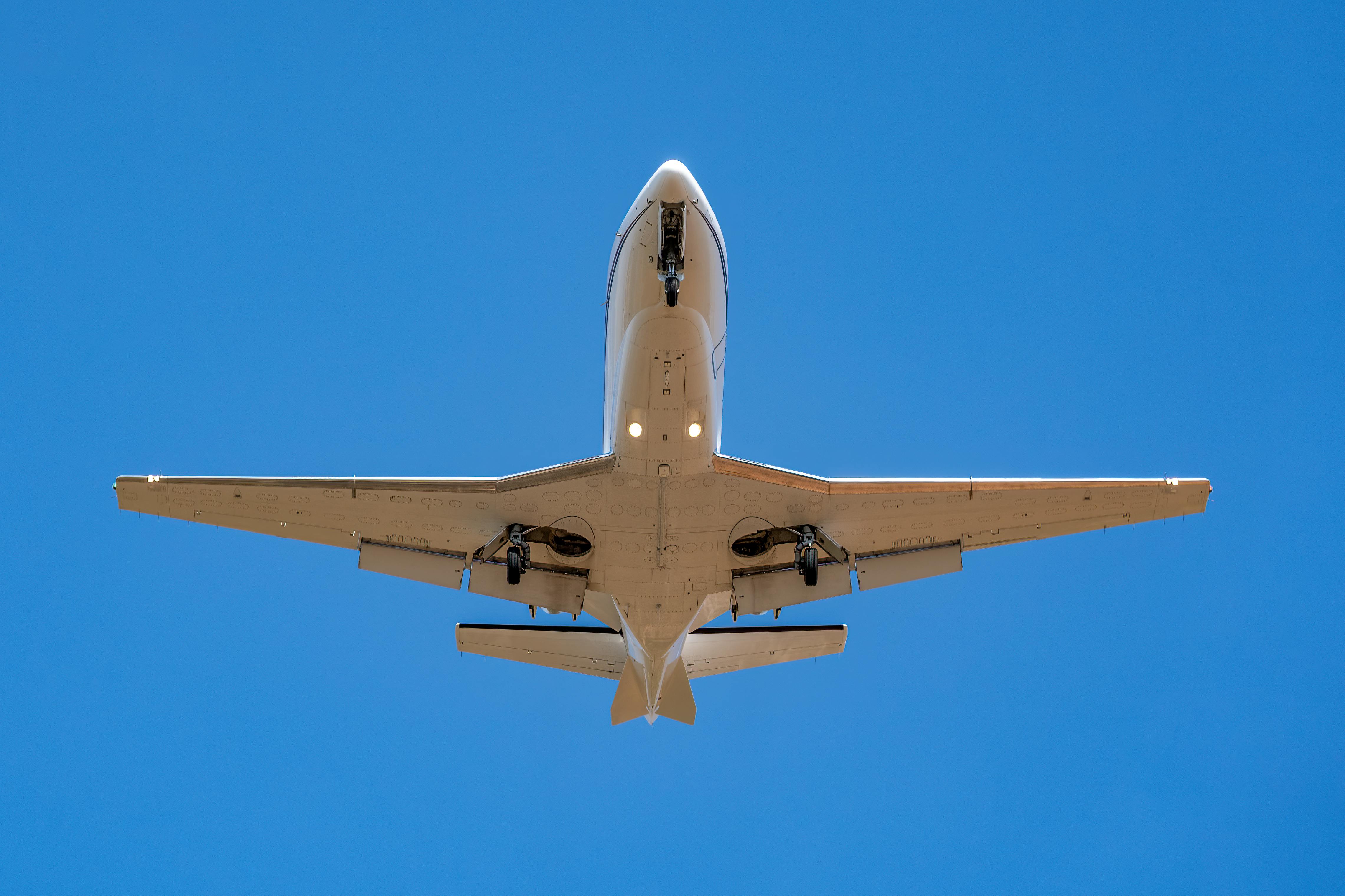 private jet flying above with blue sky