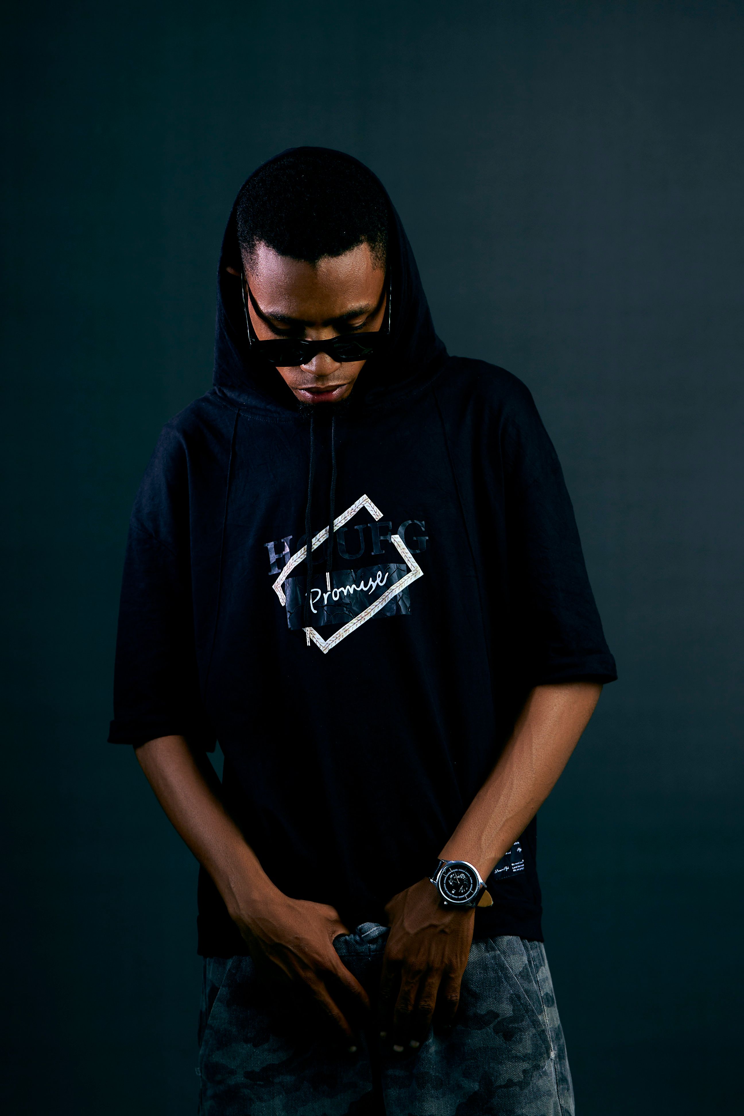 Young man wearing sunglasses and a stylish hoodie, urban fashion portrait.