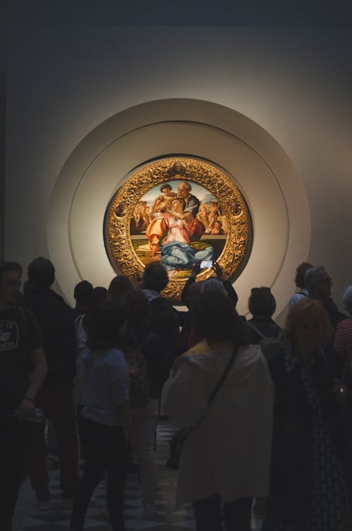聖家族の絵画を賞賛する美術館の訪問者