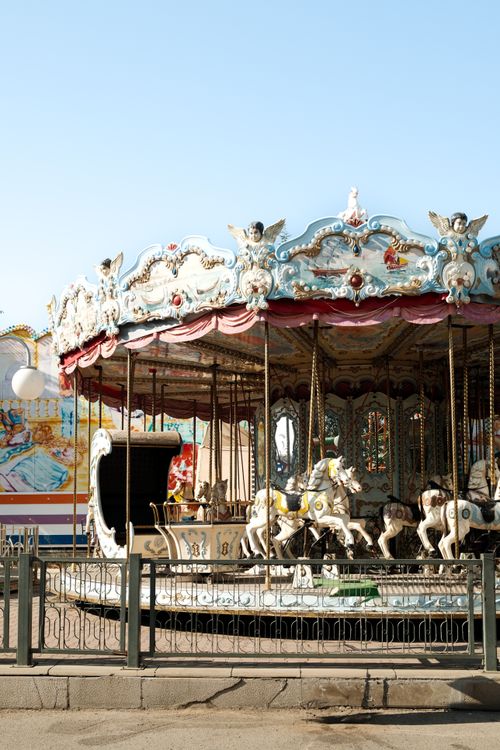 Free Ornate vintage carousel with horse figures in a sunlit park setting. Stock Photo