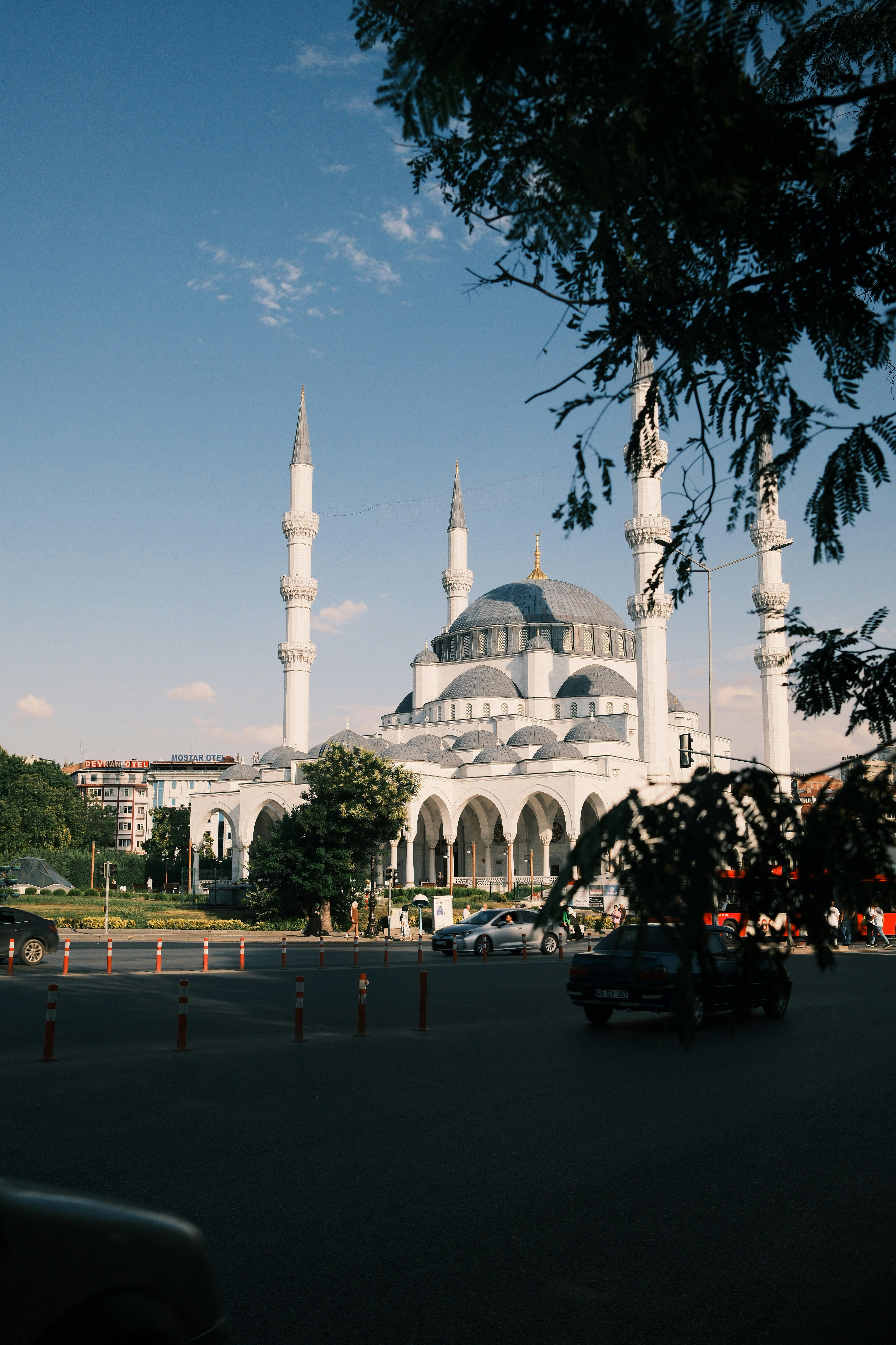 Capture of a stunning white mosque with towering minarets under the blue sky.