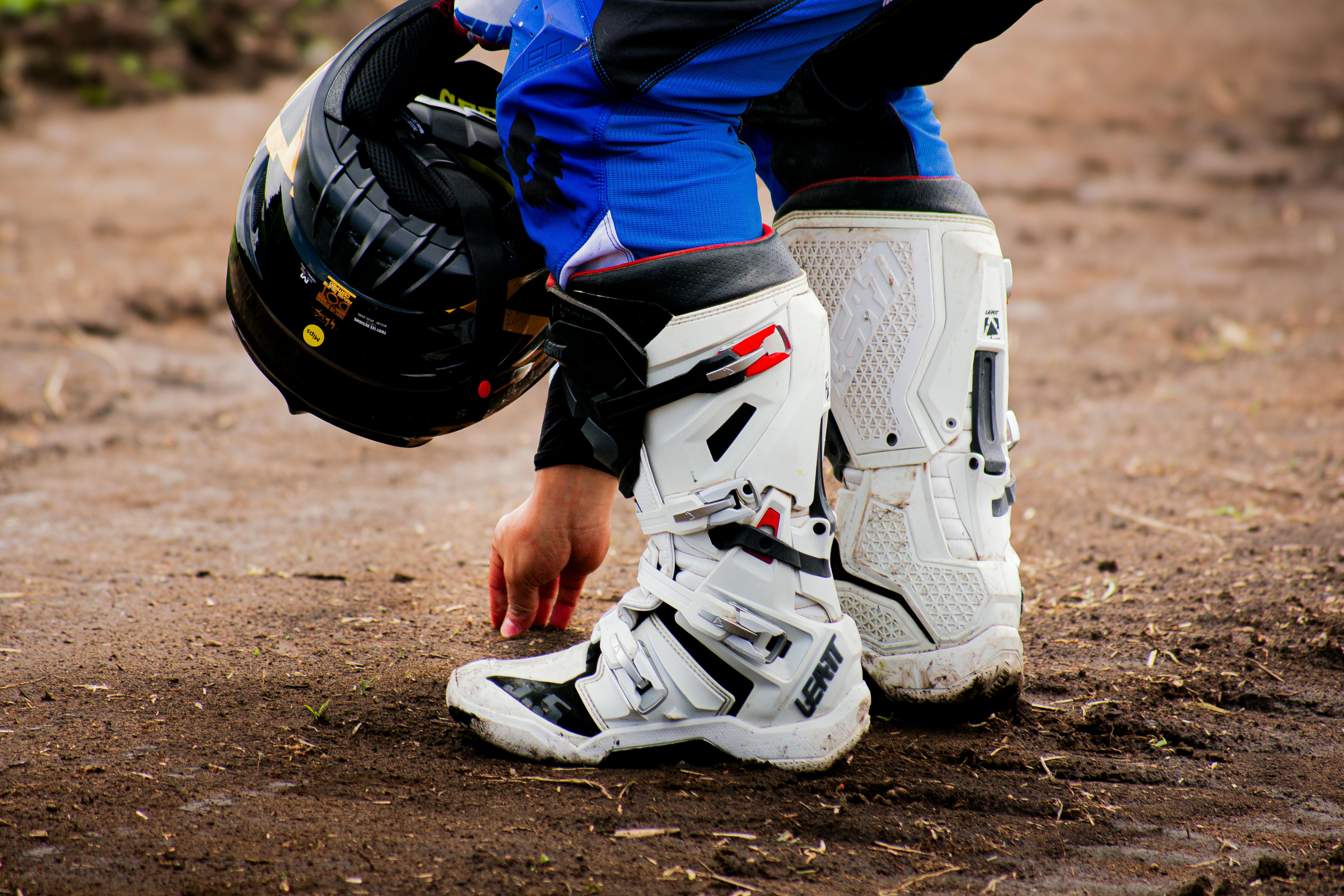 Close-up of motocross gear including helmet and boots on a dirt track in Mexico City.