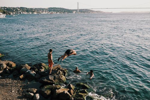 Free Young people enjoying a sunny day swimming and diving in the Bosphorus. Stock Photo