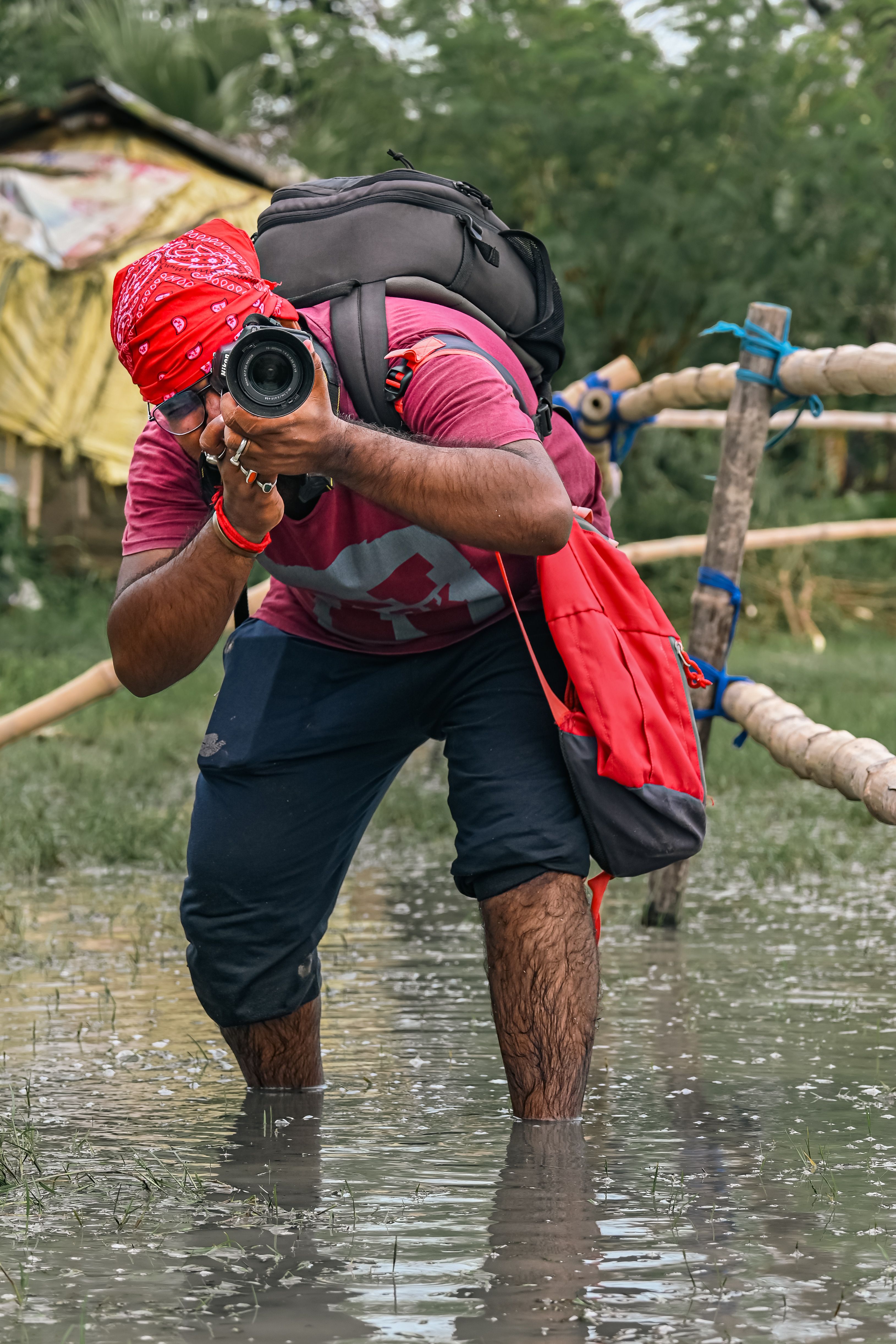 Dynamic shot of a photographer capturing nature in Kolkata's rain-soaked outdoors.