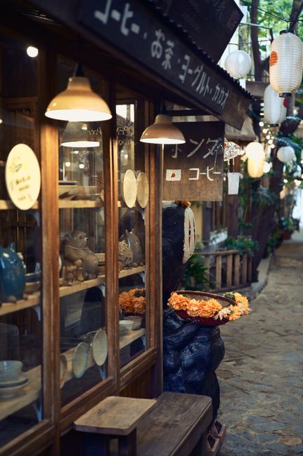 A cozy Japanese street scene featuring traditional lanterns and a quaint shopfront.