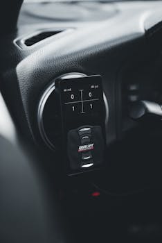 Car dashboard featuring a digital air suspension controller in sleek black interior.