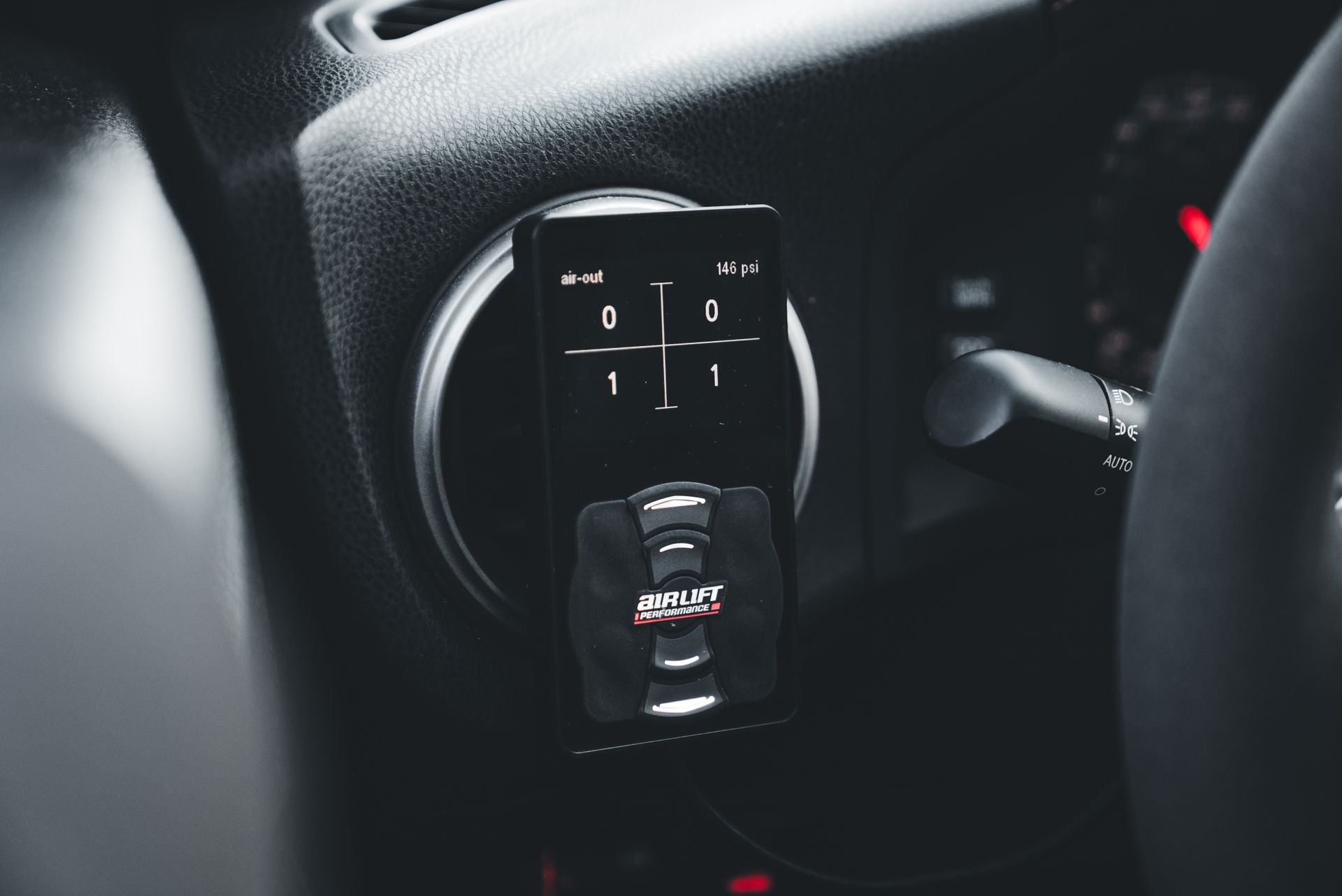 Detailed view of an AirLift Performance gauge in a car interior, showcasing precision engineering.