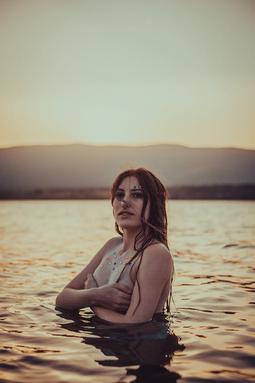 Kobieta Topless Na Ciele Wodnym Podczas Zachodu Słońca