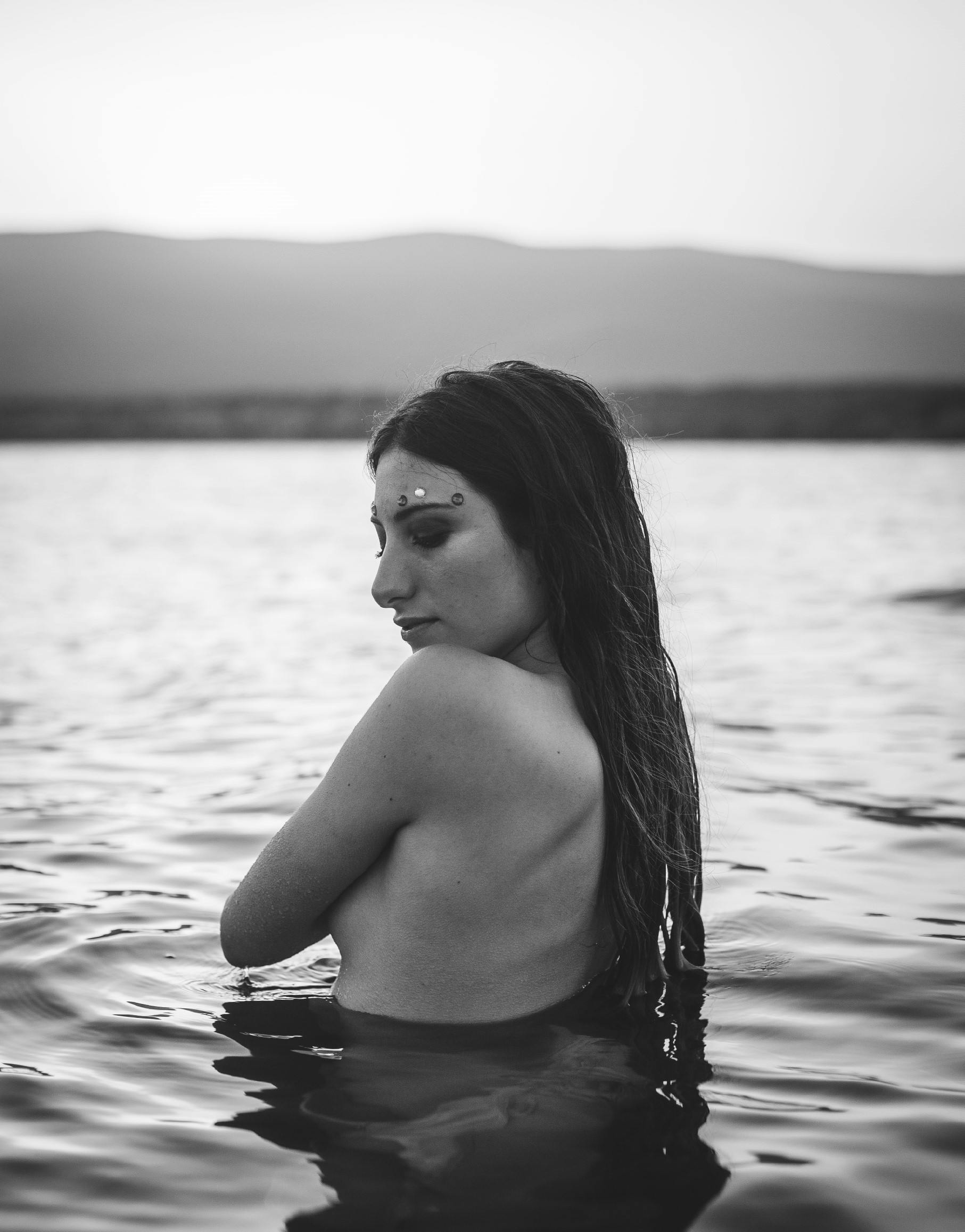 grayscale photo of topless woman in water