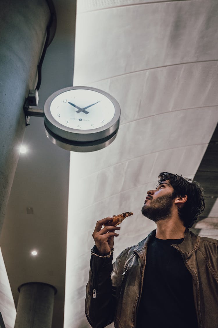 Low Angle Photo Of Man Looking Towards The Clock