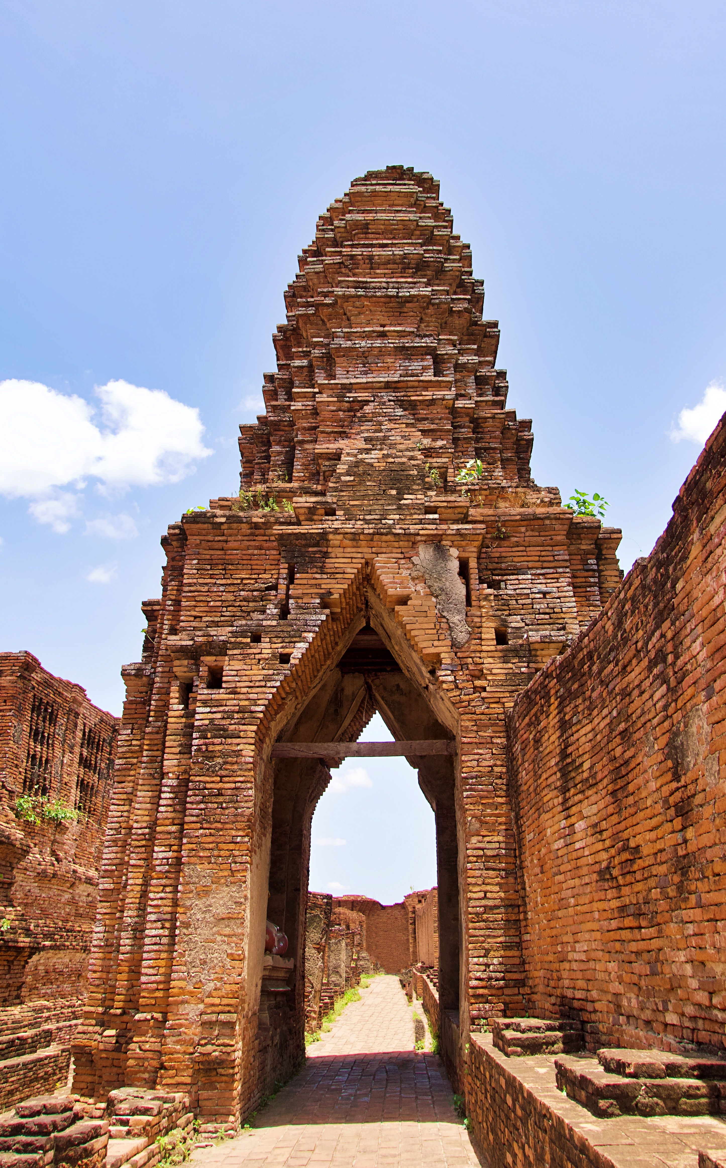 Ancient brick temple ruins under a clear blue sky in Ayutthaya, Thailand.