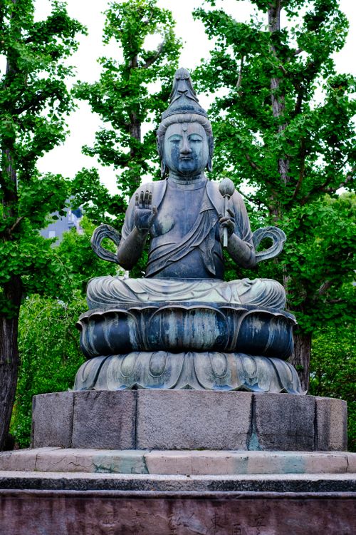 Free A serene Buddha statue in a lush outdoor setting, symbolizing peace and tranquility. Stock Photo