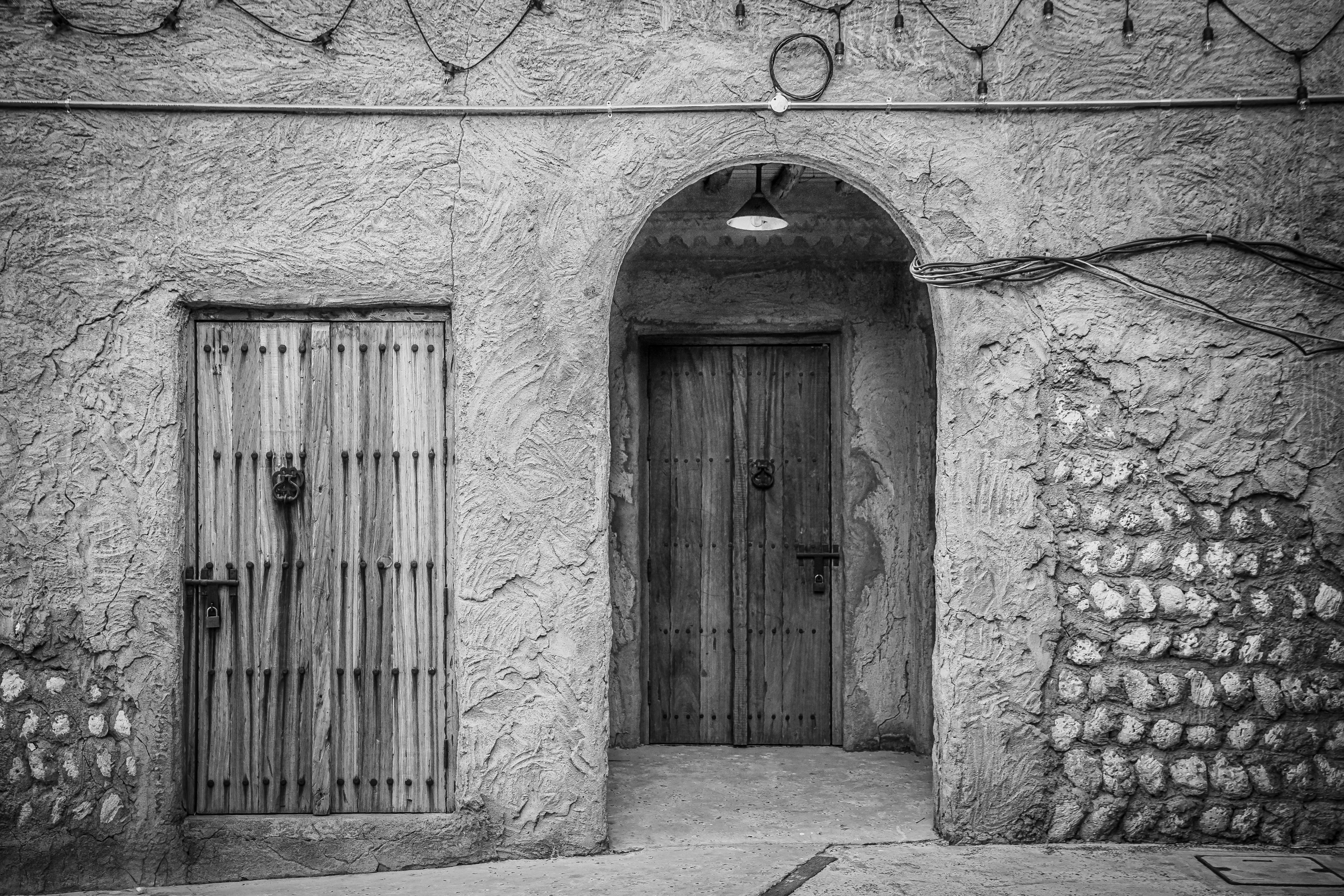 Black and white photo of traditional wooden doors in Dubai's historic Old Town.