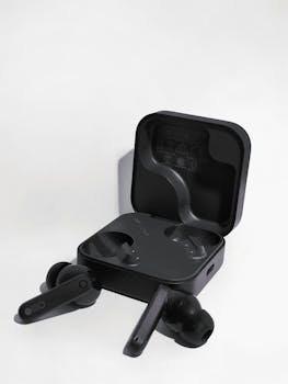 Elegant black wireless earbuds showcased in an open charging case on a white background.