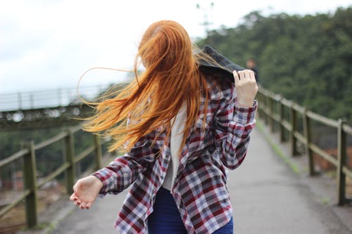 Mulher Vestindo Camisa Esporte Xadrez Com Botão E Segurando Capuz Preto