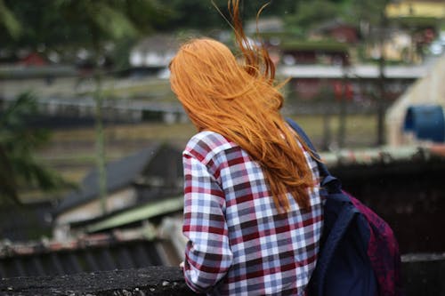 Orang Dengan Atasan Kotak Kotak Putih Dan Merah Dengan Tas Ransel Hitam Dan Merah Dalam Fotografi Fokus Dangkal