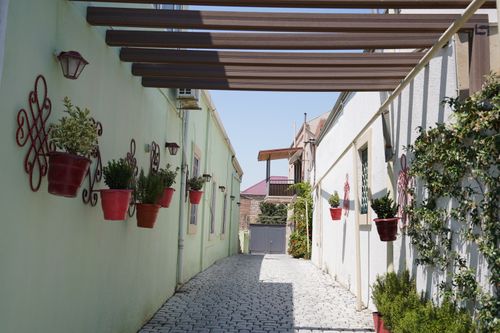 Free A picturesque alley with decorative potted plants under a shaded pergola, creating a serene atmosphere. Stock Photo