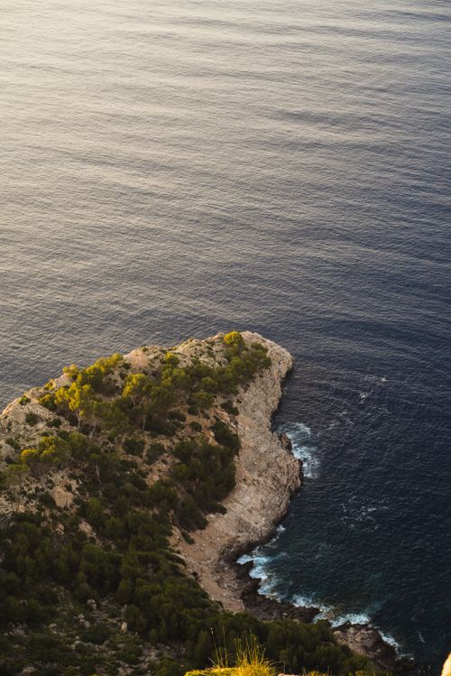 Free Stunning aerial view of rocky coastline and ocean at sunset in the Balearic Islands, Spain. Stock Photo