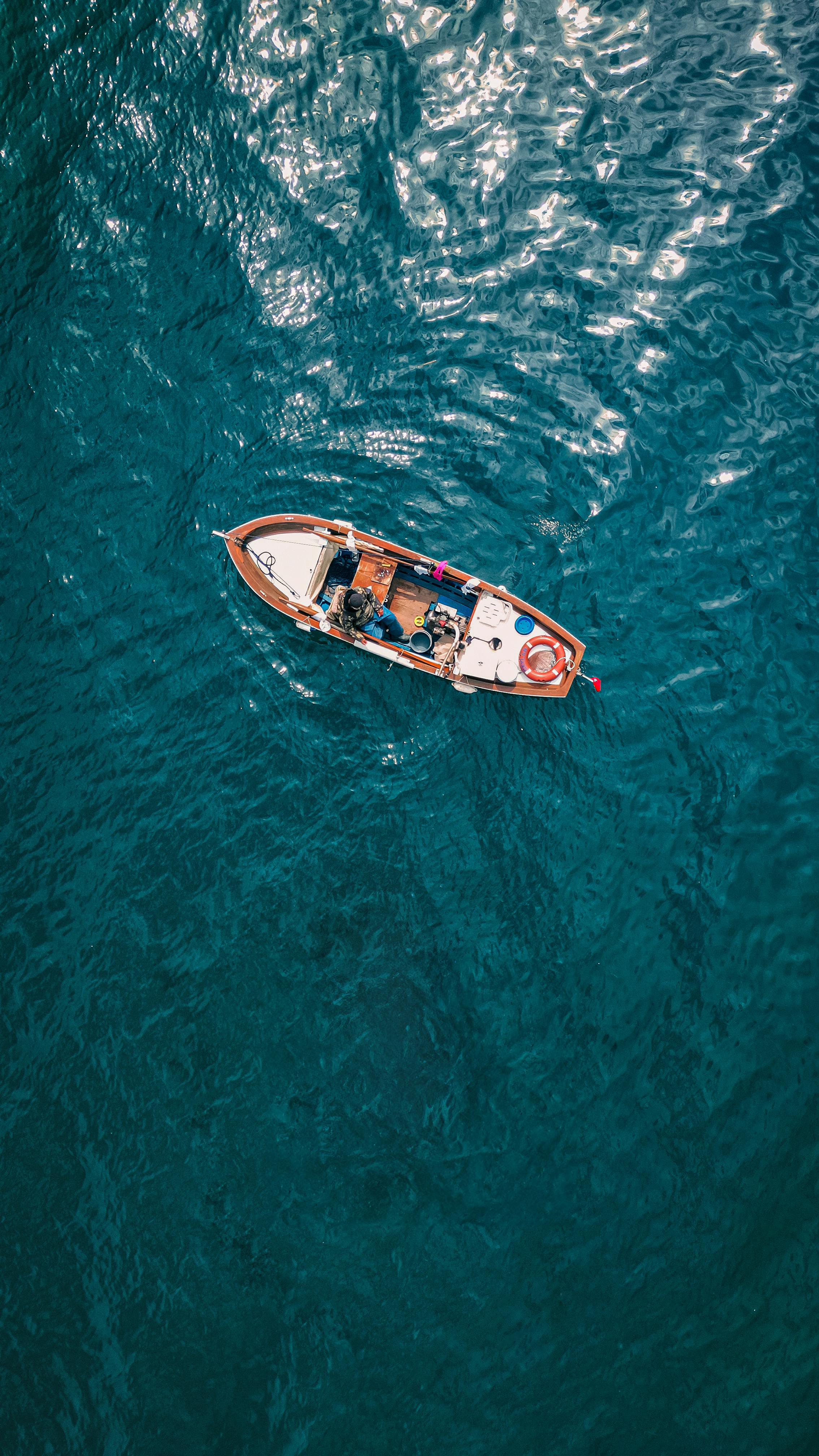 Aerial shot of a solitary boat floating on vibrant turquoise waters in Yalova, Türkiye.
