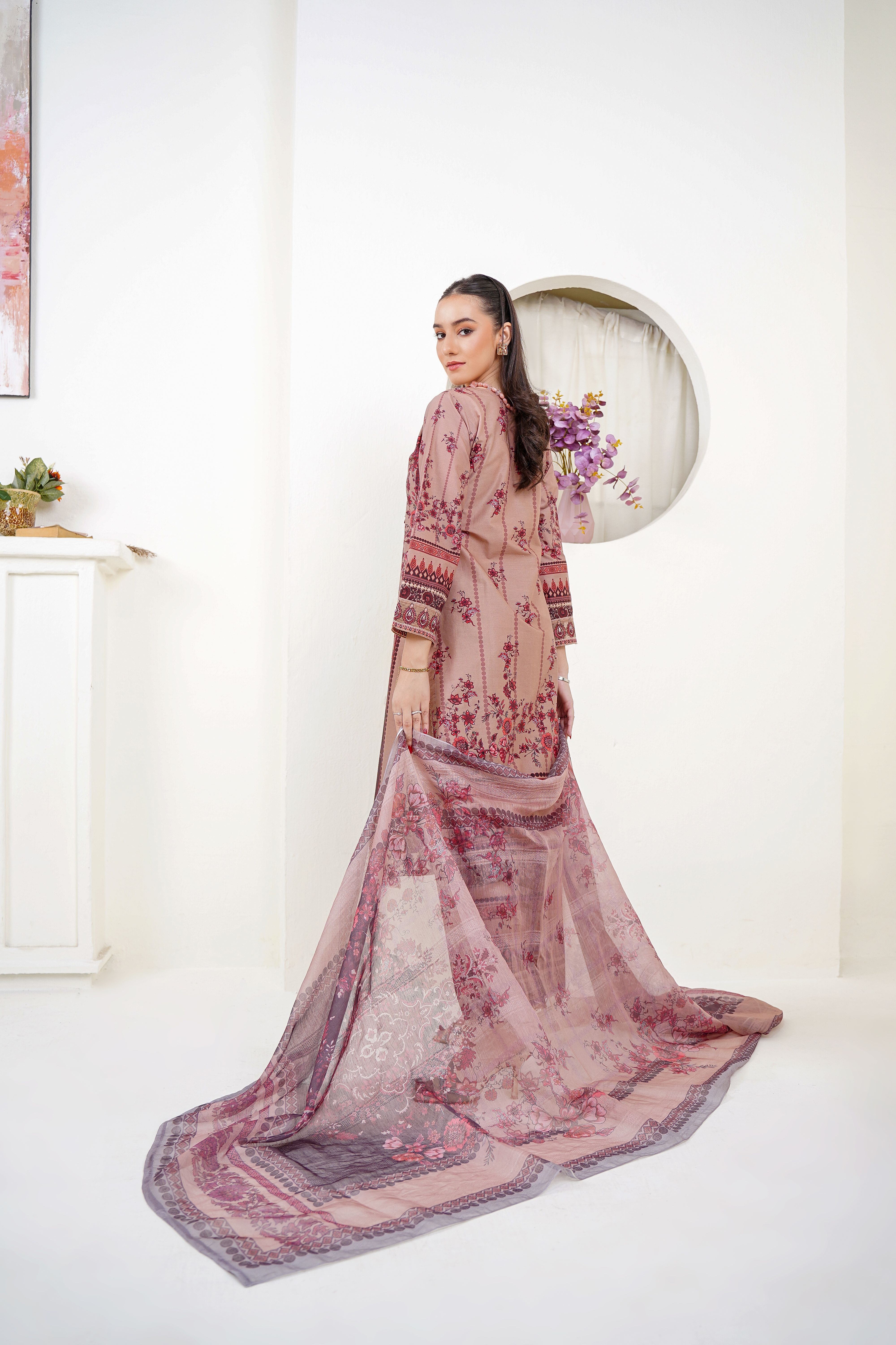 Model in eastern dress showcasing intricate design in a Lahore studio setting.