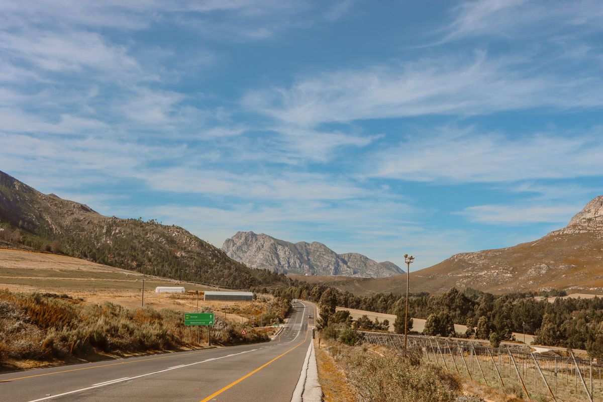 Scenic Mountain Highway Under Blue Sky · Free Stock Photo