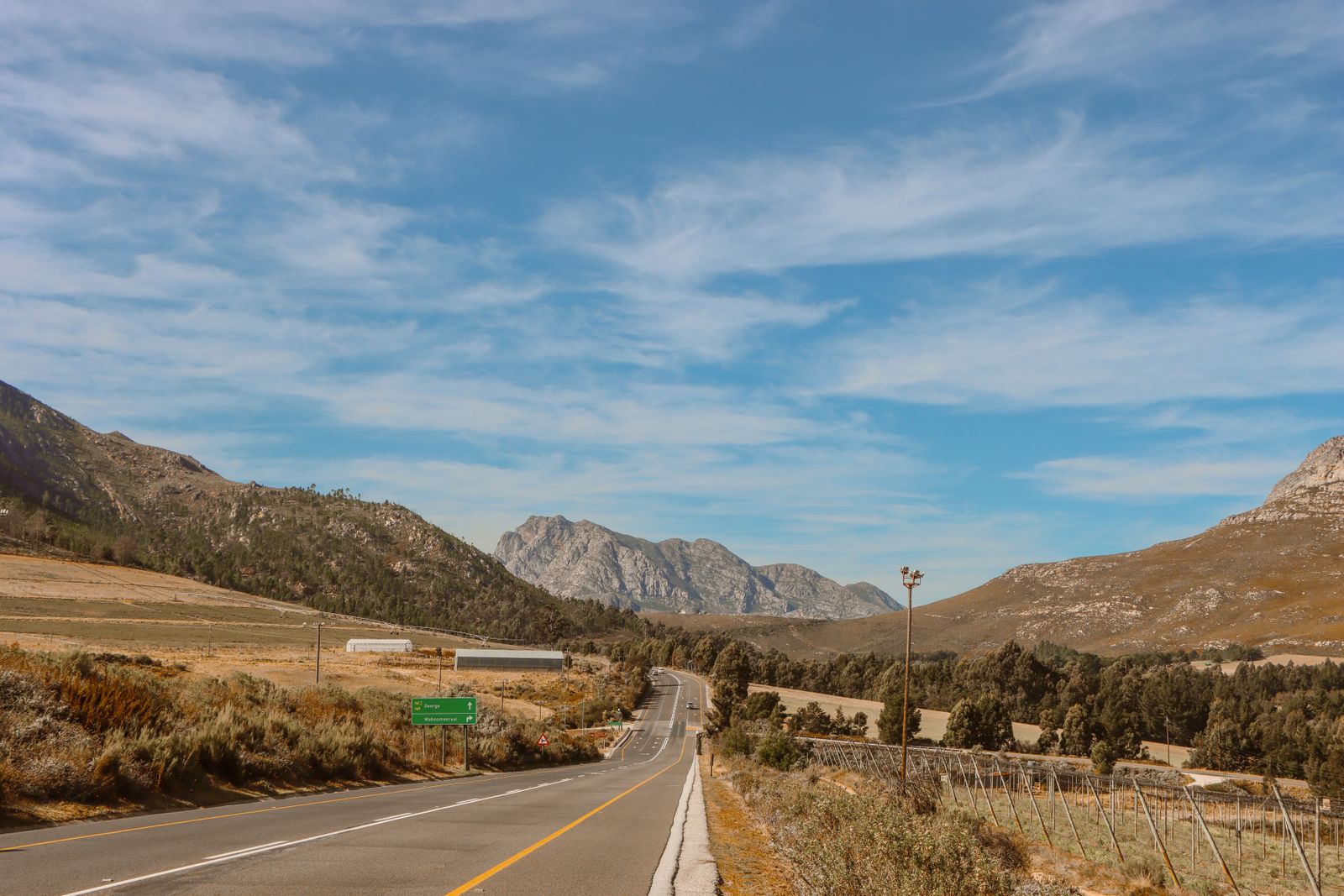 Scenic Mountain Highway Under Blue Sky · Free Stock Photo