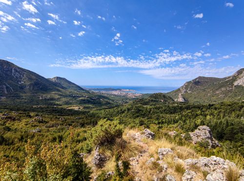 Free A breathtaking panoramic view of the mountains and coastline in Bar, Montenegro under a clear blue sky. Stock Photo