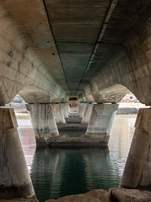 Free Intricate view of architectural symmetry beneath a bridge in Vigo, Spain, over calm waters. Stock Photo
