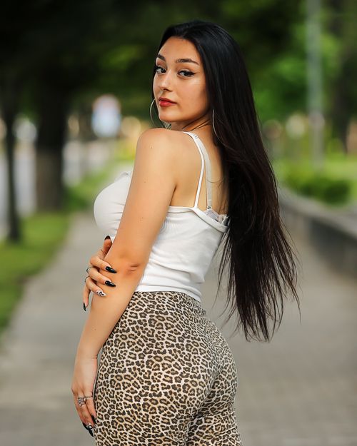 Free Elegant portrait of a woman with long hair in a fashionable outfit outdoors. Stock Photo
