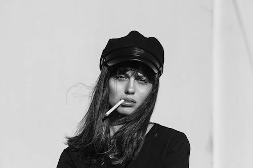 Женщина в черном топе во время курения