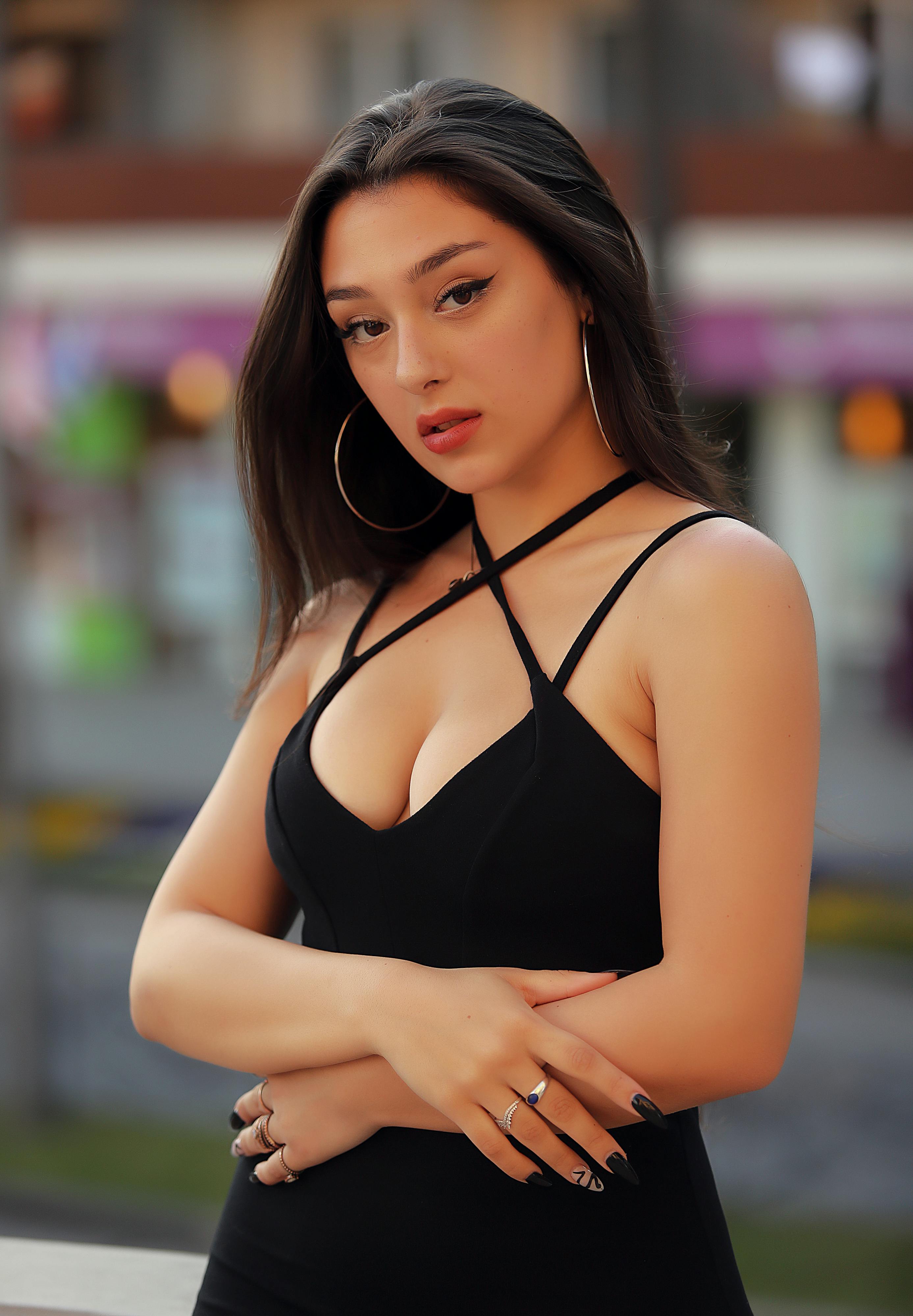 Stylish portrait of a woman with a natural expression outdoors in vibrant lighting.