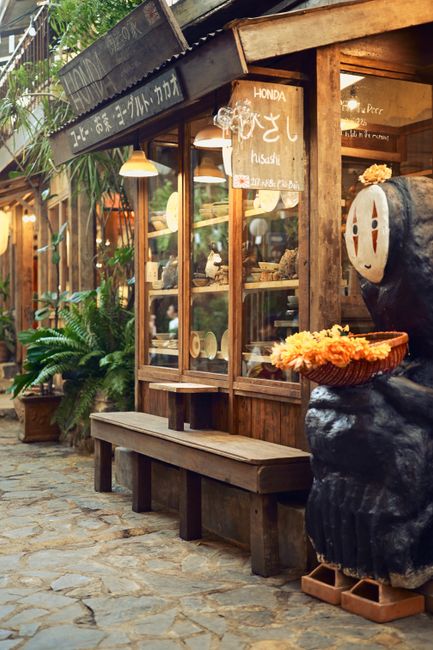 Quaint moss-covered storefront with a distinctive No-Face figure, offering a cozy rustic ambiance.